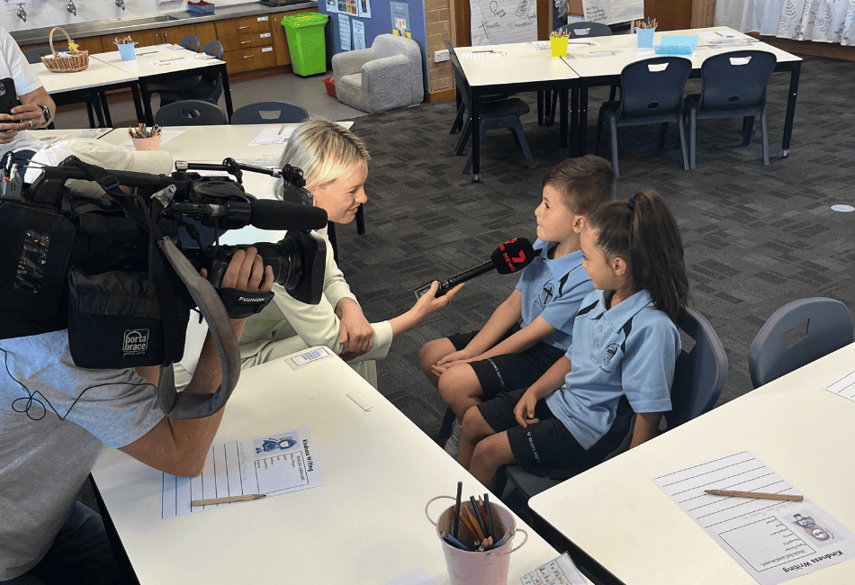 A photo of two students from St Kevin's Catholic Primary School Eastwood chatting with a 7News Sydney Reporter and Cameraman